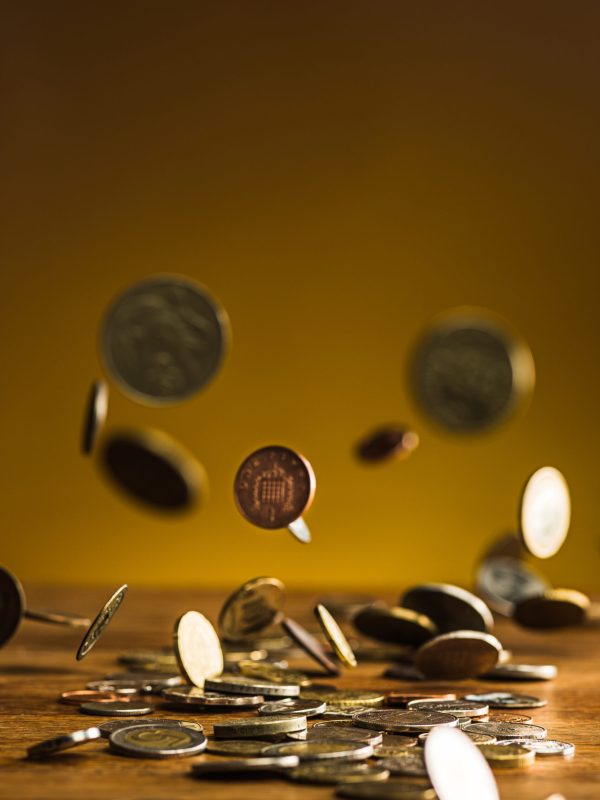 The silver and golden coins and falling coins on wooden table background
